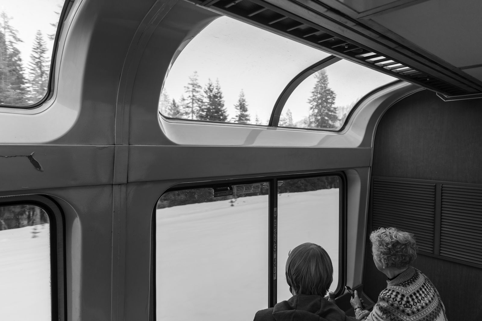 Two older women are watching as the east bound California Zephyr crosses Donner Pass between Sacramento and Reno.
