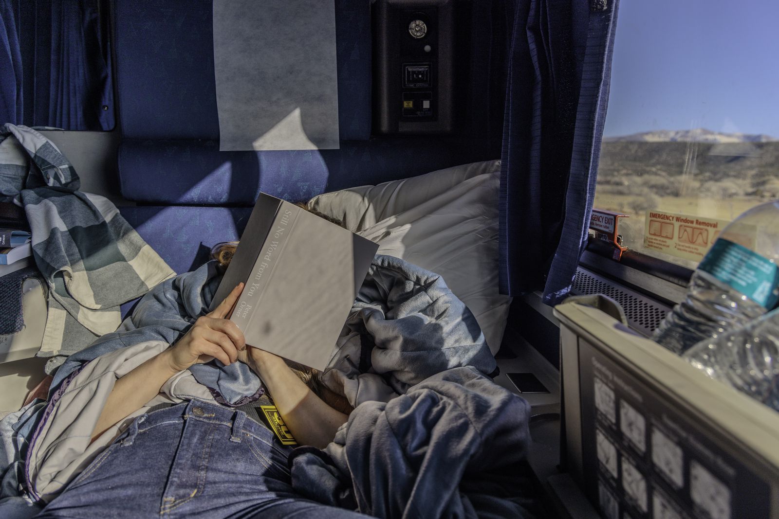 Danielle reads Still No Word from You by Peter Orner in the evening sun in an Amtrak Roomette on an eastbound California Zephyr